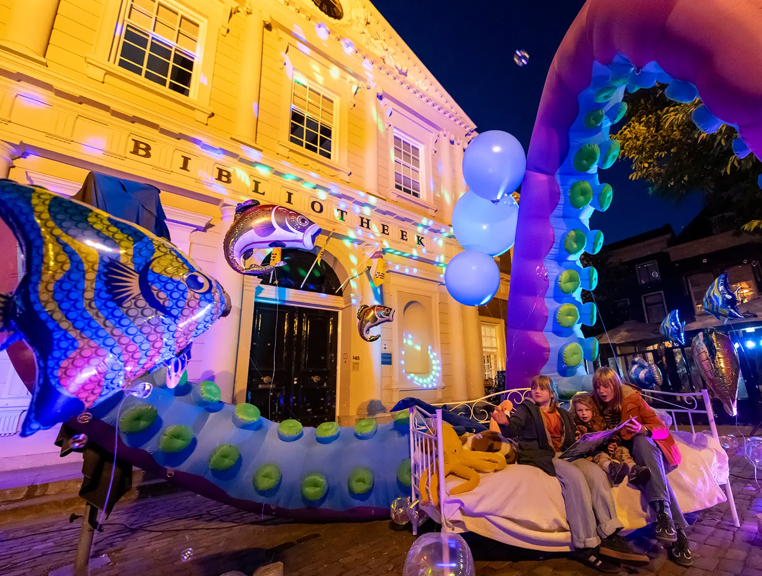Kleurrijke verlichte paradefiguren bij de Bibliotheek in Schiedam